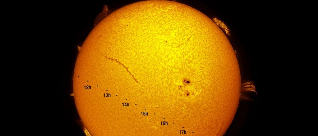 Representación artística del tránsito de Mercurio. La imagen muestra la dirección, de izquierda a derecha, que seguirá el planeta (representado a escala por el circulo negro) durante las siete horas y media que tarda en recorrer el disco solar. Las horas indicadas son en Tiempo Universal; se debe sumar una hora para Canarias y dos para el resto de España. Imagen del Sol en Halfa. Crédito: Daniel López/IAC.