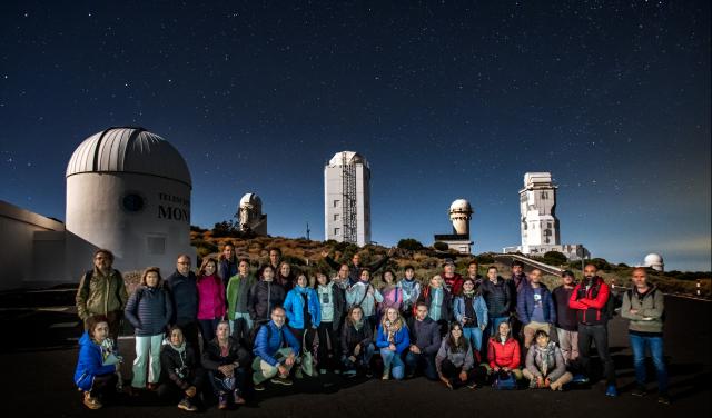 Teachers during night time observation with the solar towers at background