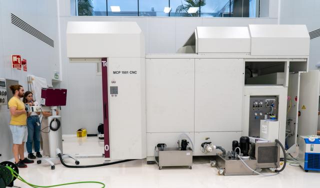 Tres ingenieras probando una máquina de gran envergadura en una sala blanca (sala limpia sur de IACTEC)