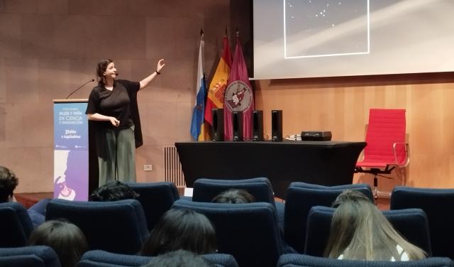 La divulgadora señala al público un área del cielo que aparece en la pantalla