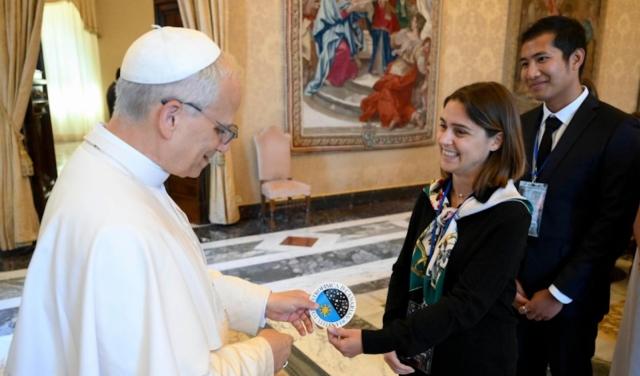 Image of the moment when doctoral students Stella Tsilia and Jun-Yan Zhang (Jerry) present Pope Leo XIV with the sticker bearing the IAC logo.