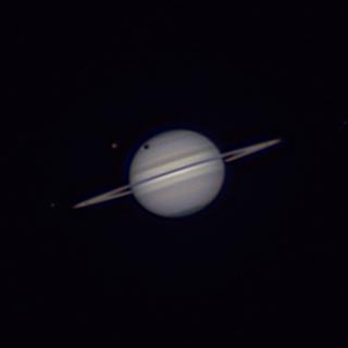 Saturno cerca del amanecer del 4 de septiembre de 2025, con su disco casi de canto. Destaca Titán (el mayor de sus satélites, con un tono anaranjado) y su sombra sobre el planeta. (A. Rosenberg / D. López /E. Matilla)