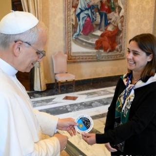 Imagen del momento en el que los doctorandos del IAC Stella Tsilia y Jun-Yan Zhang (Jerry) entregan al Papa León XIV la pegatina con el logo del IAC