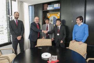 El director del IAC, Rafael Rebolo, dando la mano a Chiko Otani del Insituto Riken. A su lado, Osamu Tajima, representante del High Energy Accelerator Research Organisation (KEK), y Ricardo Génova y José Alberto Rubiño, investigadores del IAC. Crédito: Mi 8520