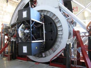 Imagen de CanariCam instalado en el Gran Telescopio CANARIAS (GTC). La parte hexagonal que hay entre las dos cajas negras de electrónica es el criostato, que está cerrado herméticamente. En el interior del criostato se recibe la luz que llega de los objet 8176