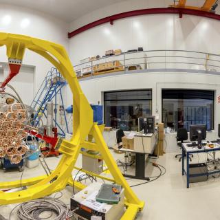 Panoramic view of one the areas of the Assembly, Integration and Verification room Panoramic view of one the areas of the Assembly, Integration and Verification room. Large laboratory with work benches and multiple electronic devices and computers, with a large mechanical structure in assembly phase