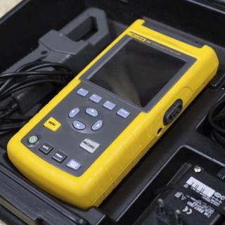 Detalle del analizador FLUKE en su maletín de transporte Detalle del analizador FLUKE en su maletín de transporte. Dispositivo portátil resistente con botones y una pequeña pantalla colocado en su maletín